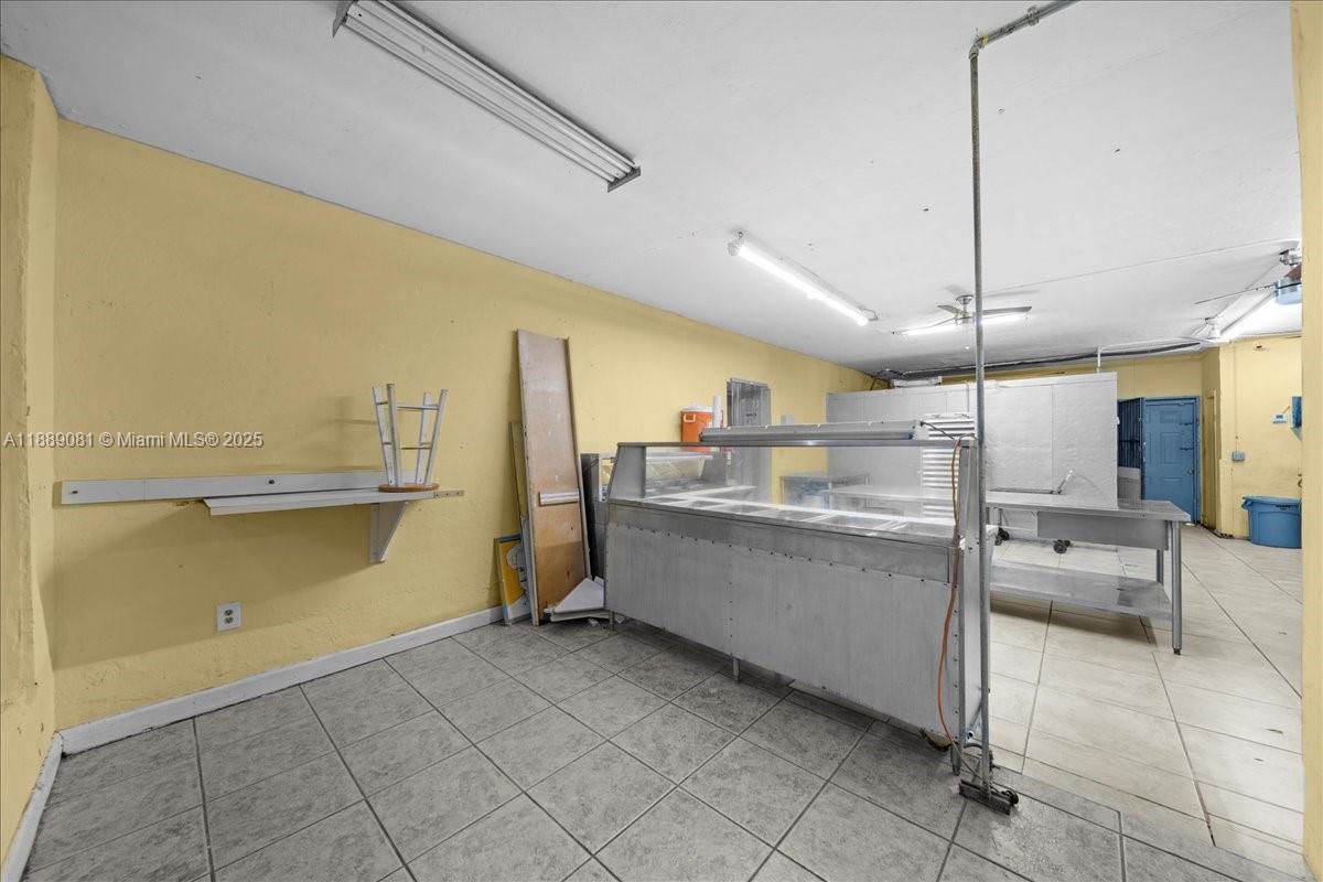 This commercial kitchen space features tiled flooring, yellow walls, and a stainless steel prep station — 2313 NW 27th Ave, Miami FL 33142, MIAMI, FL
