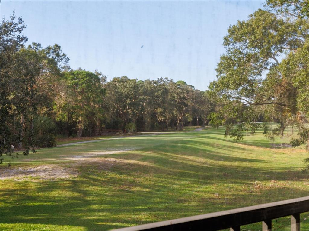 A view of a grassy golf course fairway lined with mature trees — 7794 EAGLE CREEK DRIVE UNIT 7794, SARASOTA, FL