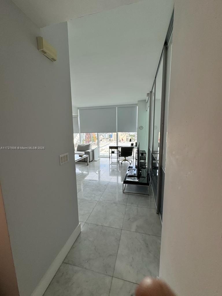 A bright room with light-colored tile flooring, a desk, a chair, and floor-to-ceiling windows — 1040 Biscayne Blvd # 1505, Miami FL 33132, MIAMI, FL