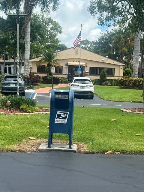 A blue USPS collection box stands on a lawn in front of a suburban building — 628 Sea Pine Way # H1, FL 33415, FL