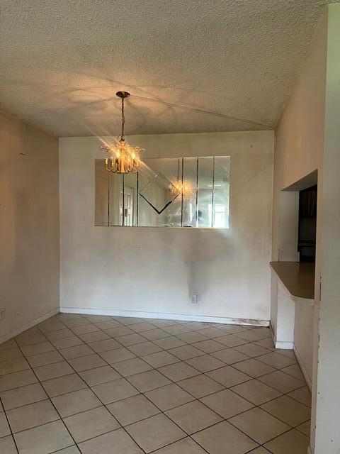 A dining area features a tiled floor, a chandelier, and a large wall-mounted mirror — 628 Sea Pine Way # H1, FL 33415, FL