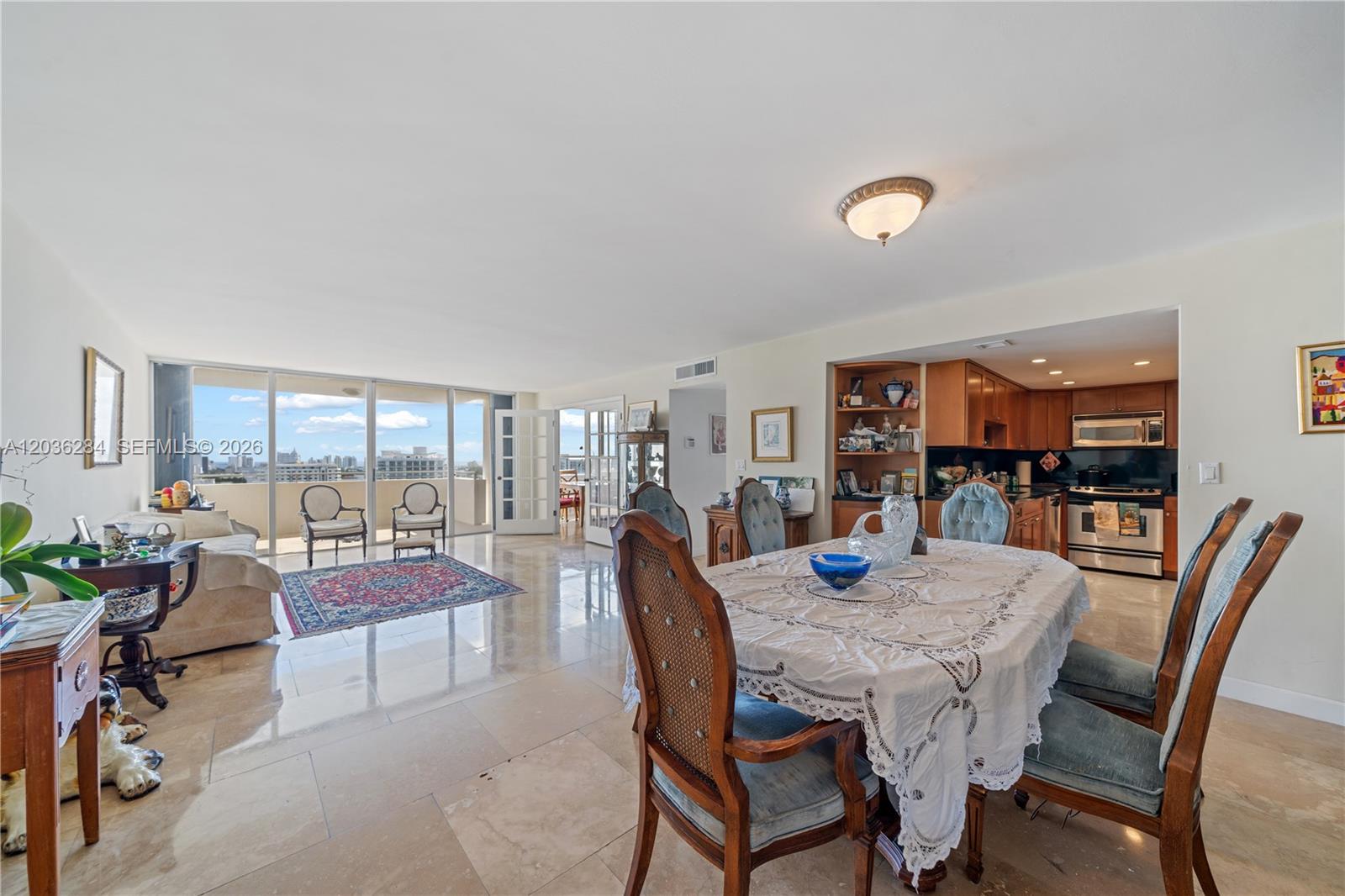 An open-concept living and dining area features tile floors, a balcony, and a kitchen — 11 Island Ave # 1708, Miami Beach FL 33139, MIAMI BEACH, FL