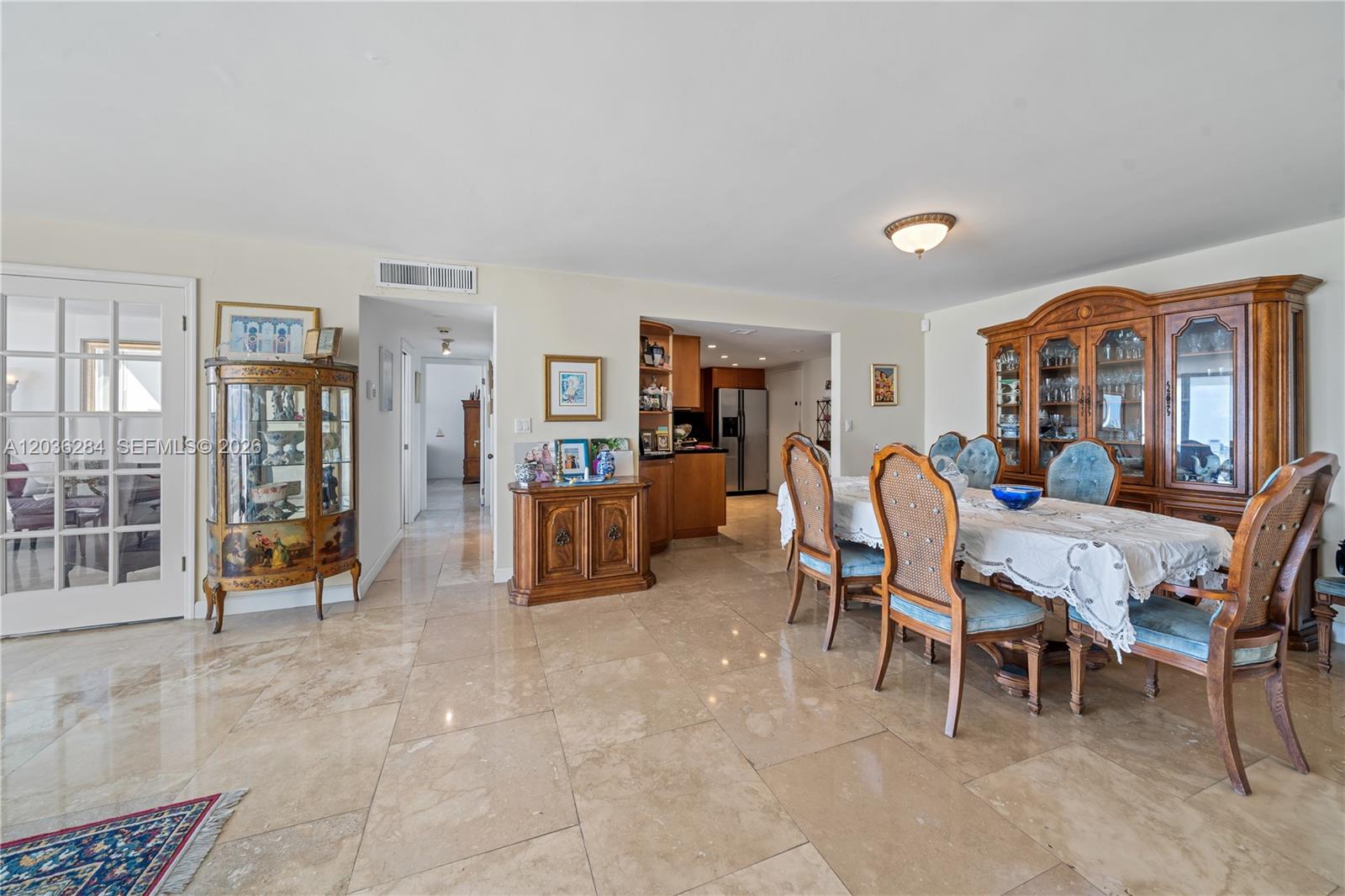A dining room features a large wooden hutch, a table with chairs, and tile flooring — 11 Island Ave # 1708, Miami Beach FL 33139, MIAMI BEACH, FL