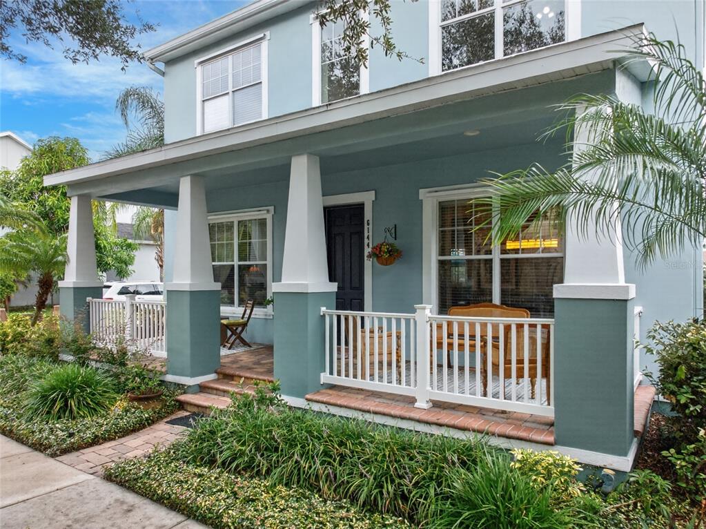 A two-story light blue house features a covered front porch with white railings and columns — 6144 CLIFF HOUSE LANE, RIVERVIEW, FL