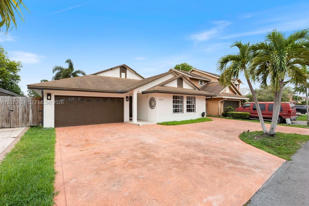 A single-story house with a brown garage door and a stamped concrete driveway — 19080 NW 77th Ct, Hialeah FL 33015, HIALEAH, FL