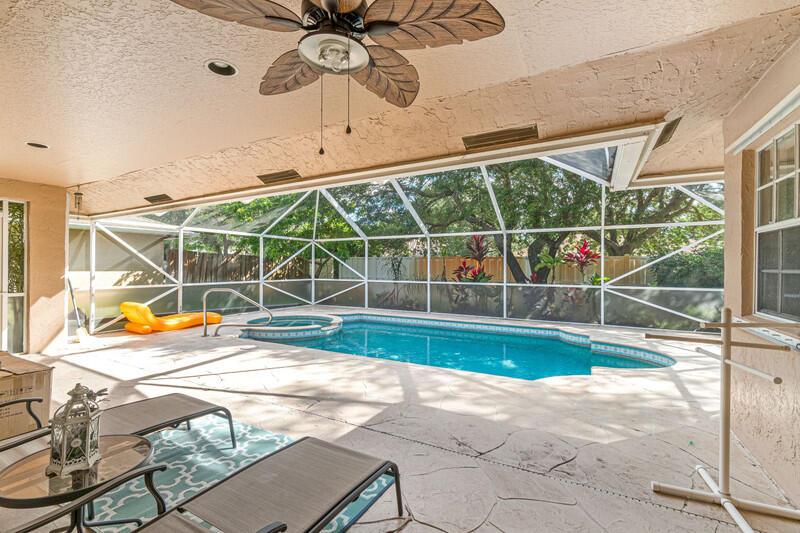 A covered patio features a swimming pool, a hot tub, and a ceiling fan — 1840 Hollyhock Road, Wellington FL 33414, WELLINGTON, FL
