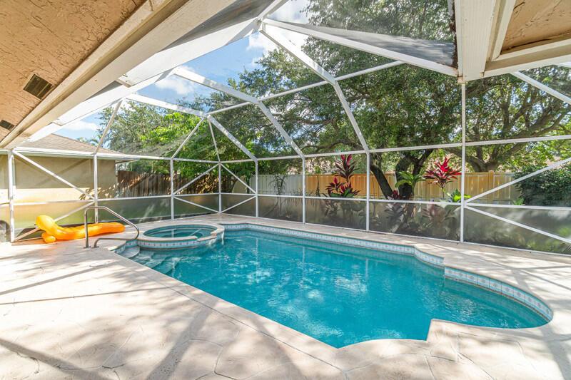 A swimming pool and hot tub are enclosed within a screened-in patio area — 1840 Hollyhock Road, Wellington FL 33414, WELLINGTON, FL