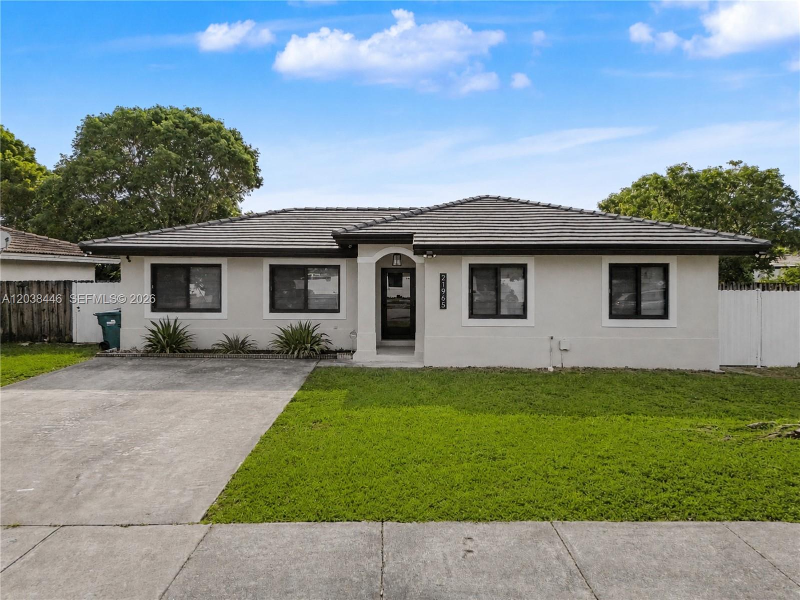 A single-story house with a concrete driveway, a tiled roof, and a front lawn — 21965 SW 125th Ave, Miami FL 33170, MIAMI, FL