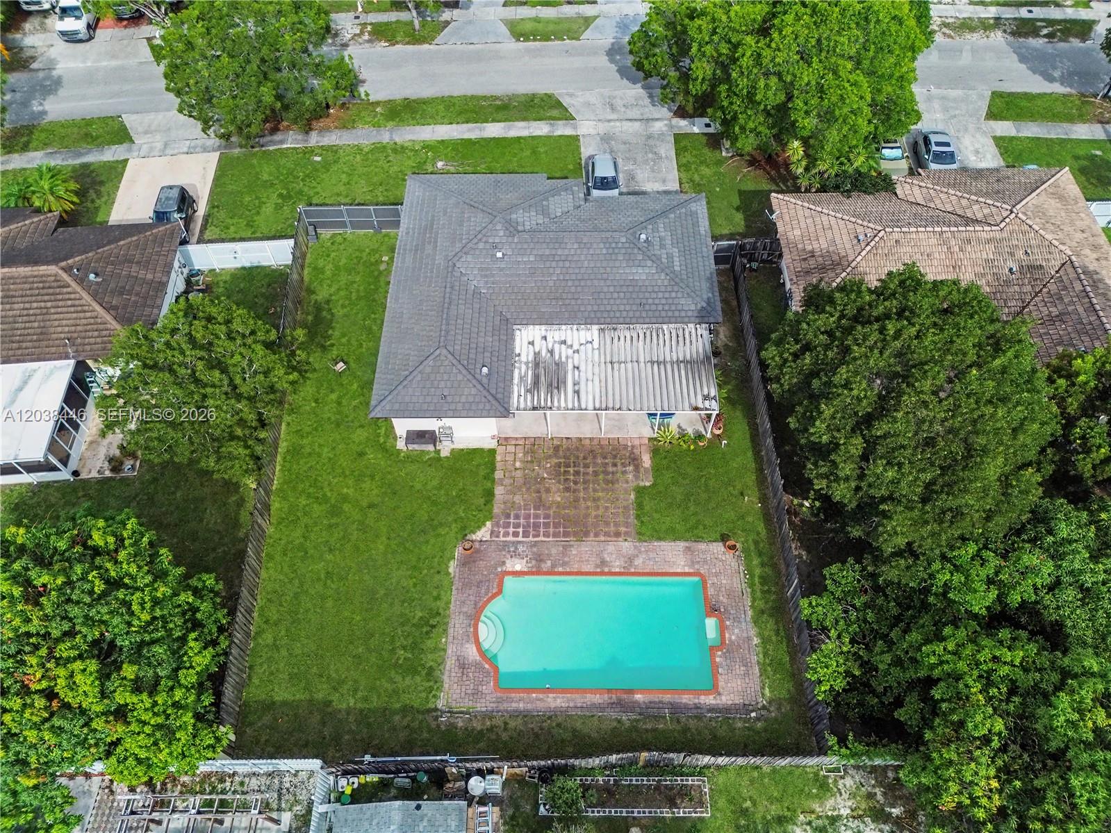 An aerial view shows a house with a gray roof, a pool, and a backyard — 21965 SW 125th Ave, Miami FL 33170, MIAMI, FL
