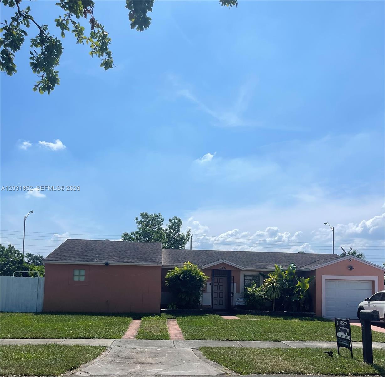 The exterior entrance features a white door with rectangular panels and a metal security gate — 19391 NW 57th Ct, Hialeah FL 33015, HIALEAH, FL