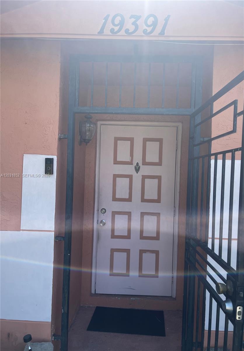 An entryway leads into a tiled living area featuring two decorative deer statues and rocking chairs — 19391 NW 57th Ct, Hialeah FL 33015, HIALEAH, FL