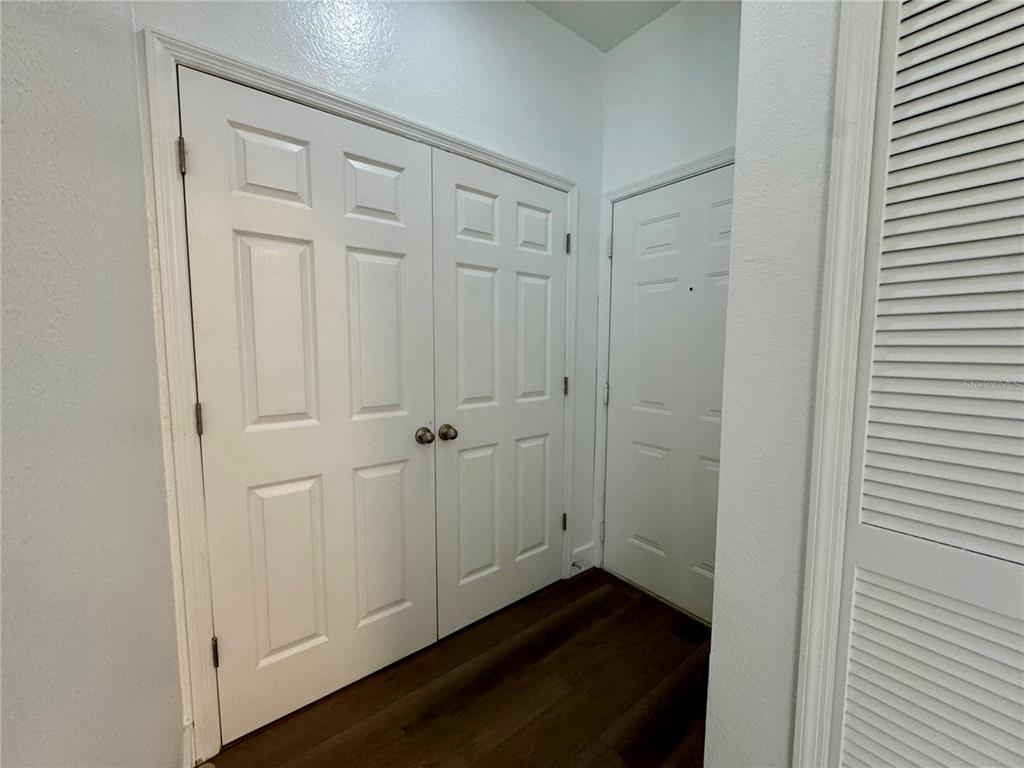 A hallway features white paneled double doors, a single door, and a louvered closet door — 7109 YACHT BASIN AVENUE UNIT 418, ORLANDO, FL