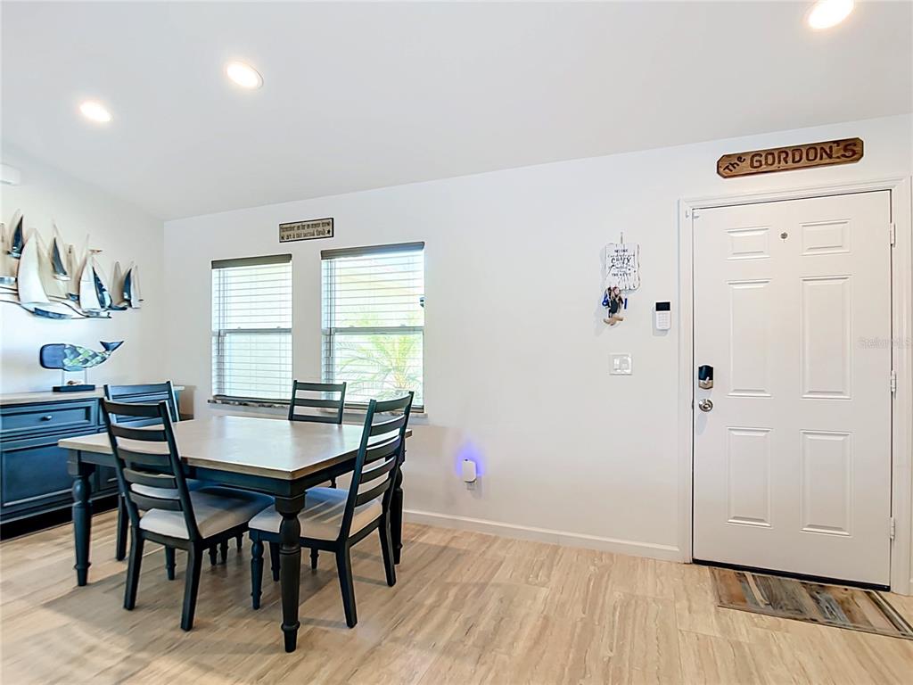 A dining area features a wooden table, four chairs, a blue sideboard, and a white door — 10024 LEBANON DR, PORT CHARLOTTE, FL