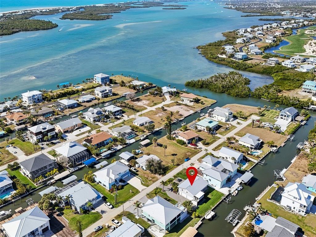 An aerial view shows a coastal neighborhood with houses situated along residential canals — 10467 SHERMAN STREET, ENGLEWOOD, FL