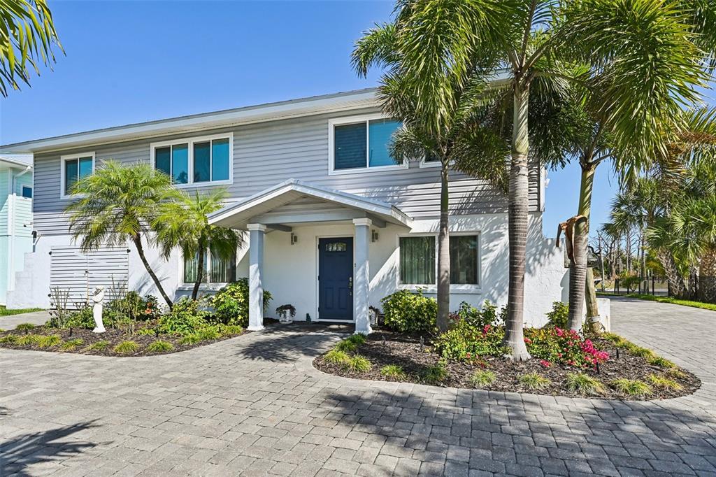 A two-story house with gray siding, a blue front door, and a paved driveway — 10467 SHERMAN STREET, ENGLEWOOD, FL