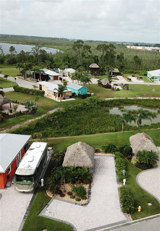 An aerial view shows a residential RV resort with paved driveways, tiki huts, and landscaping — 3258 RED TAIL HAWK DRIVE, POLK CITY, FL
