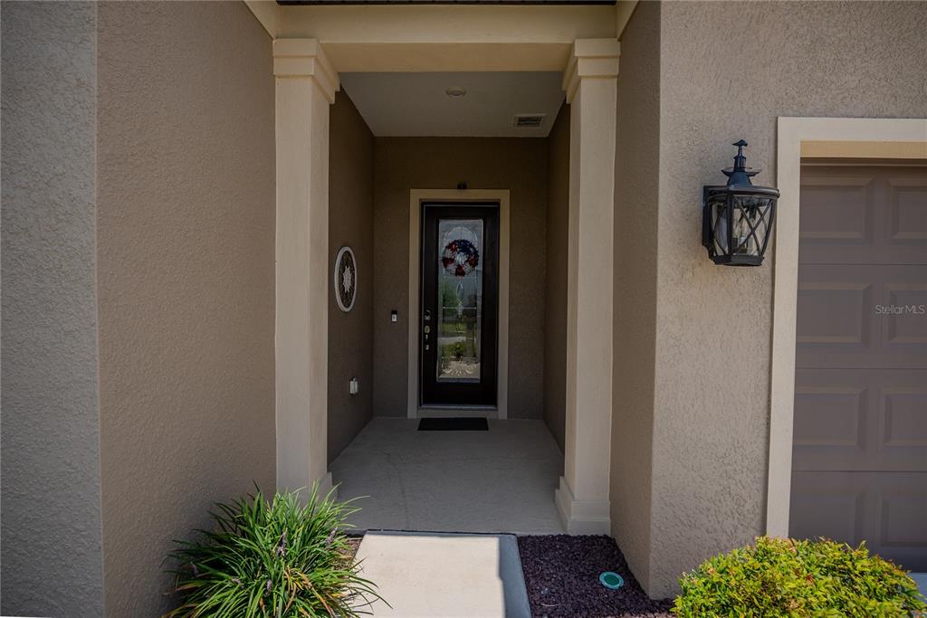 The exterior view shows a covered entryway with a front door and a garage — 9125 SW 57TH PLACE ROAD, OCALA, FL