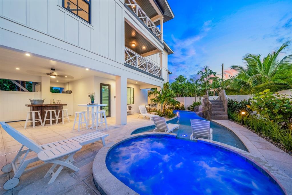 A backyard patio features a swimming pool, a hot tub, and an outdoor bar area — 6910 MIDNIGHT PASS ROAD UNIT A, SARASOTA, FL