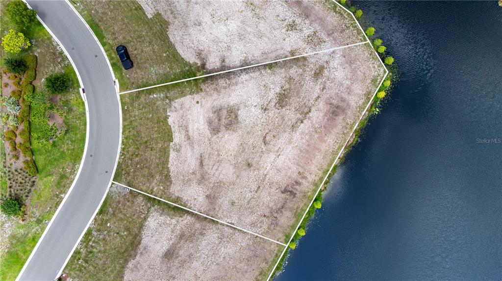 An aerial view shows a vacant, irregularly shaped residential lot bordering a lake — LOT 32, CROMWELL RD, ORLANDO, FL