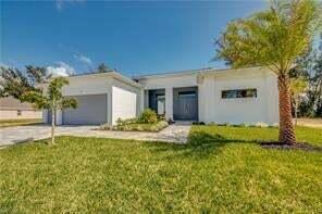 A modern white single-story house with a two-car garage and a palm tree in front — 618 N Federal Highway, FL 33460, FL