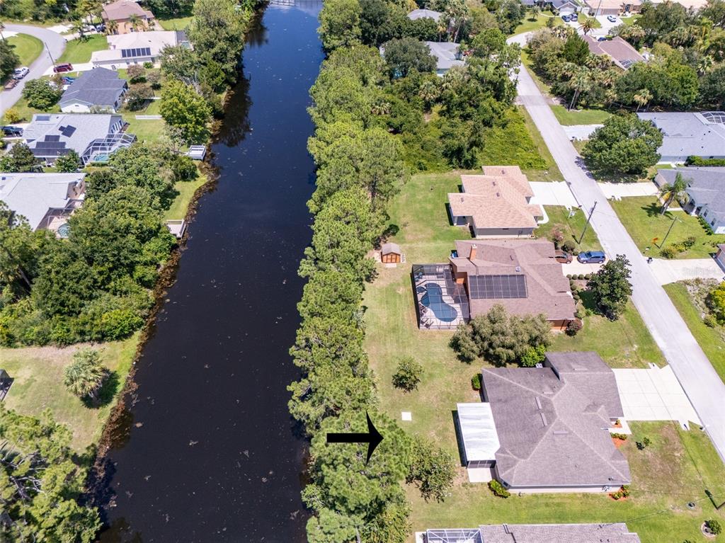 An aerial view shows a canal bordered by trees next to several residential houses — 95 BICKFORD DRIVE, PALM COAST, FL