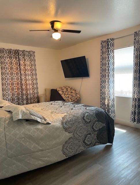 A bedroom features a bed with patterned bedding, a wall-mounted television, and geometric print curtains — 120 B STREET, LAKE WALES, FL