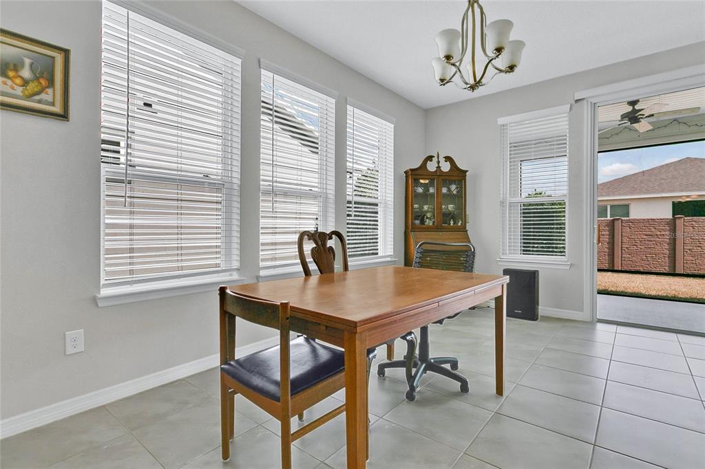 A dining area features a wooden table, two chairs, a hutch, and tile flooring — 4339 NW 56TH COURT, OCALA, FL
