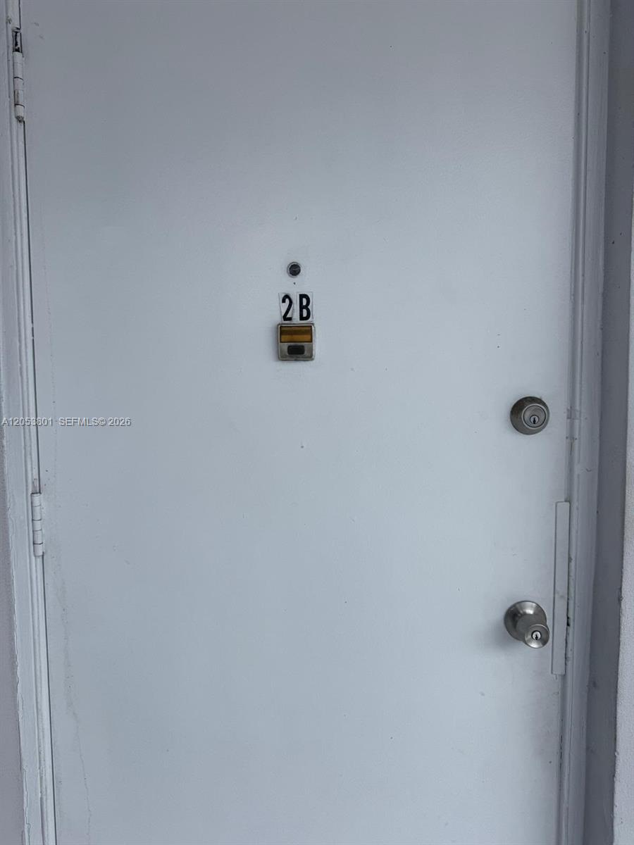 A white door with a peephole, a 2B unit number plate, and two metal locks — 2435 Van Buren St APT 2B, Hollywood FL 33020, HOLLYWOOD, FL