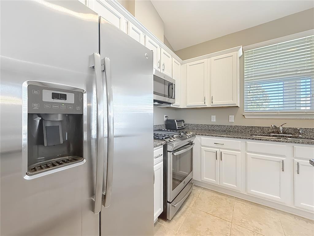 An entryway features beige walls, tile flooring, a white front door, and an adjacent doorway — 5647 NW 37TH LANE ROAD, OCALA, FL