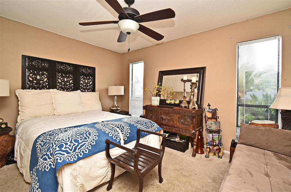 A bedroom features a bed with a decorative headboard, a ceiling fan, and a wooden dresser — 686 LAKE VILLAS DRIVE UNIT 686, ALTAMONTE SPRINGS, FL