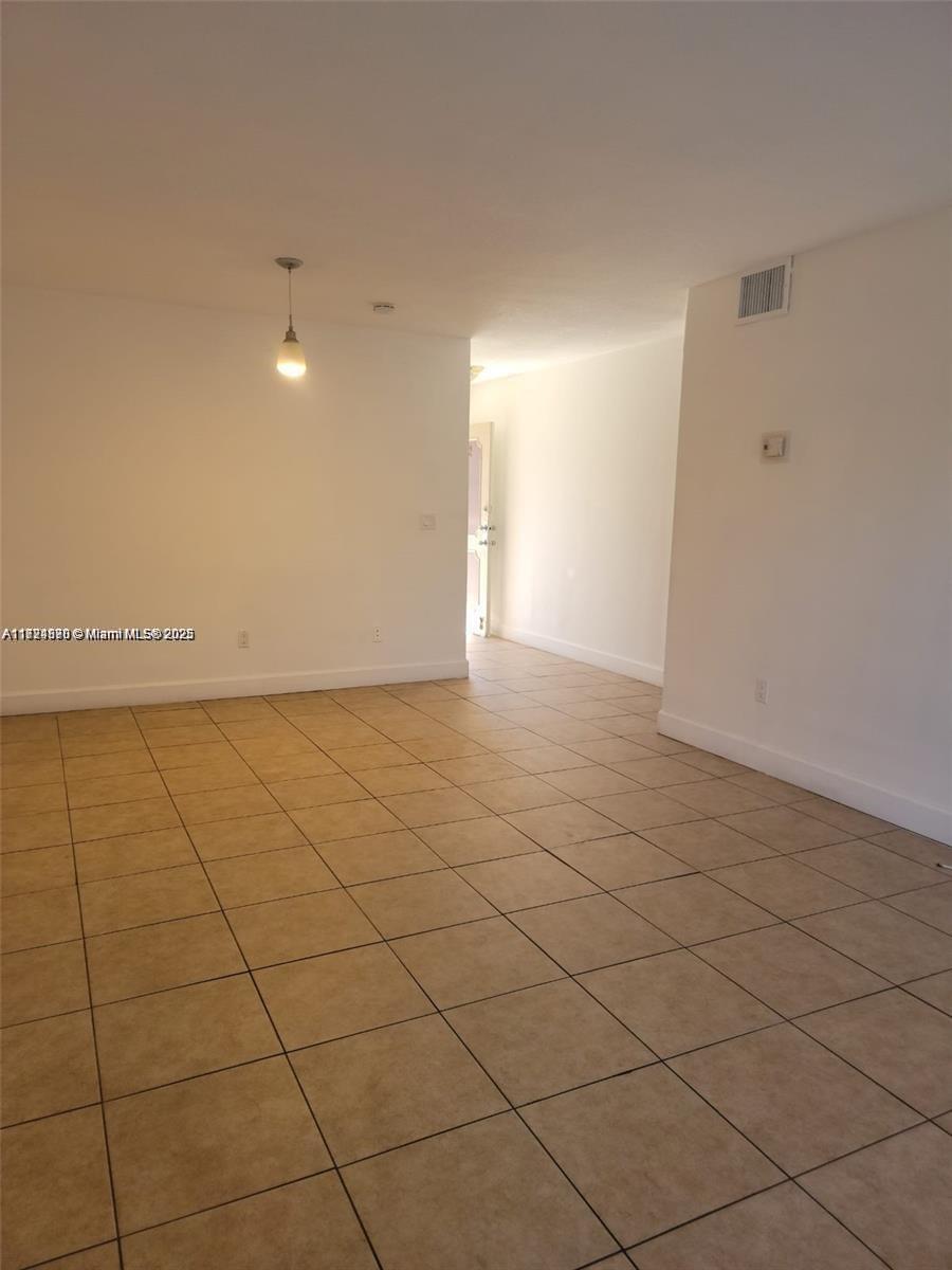 This interior view shows an empty room with beige tile flooring and white walls — 2800 NW 56th Ave # B202, Lauderhill FL 33313, LAUDERHILL, FL