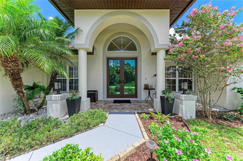 The exterior entrance features a covered arched porch with double doors and two white columns — 16352 CHICOPEE AVENUE, PORT CHARLOTTE, FL