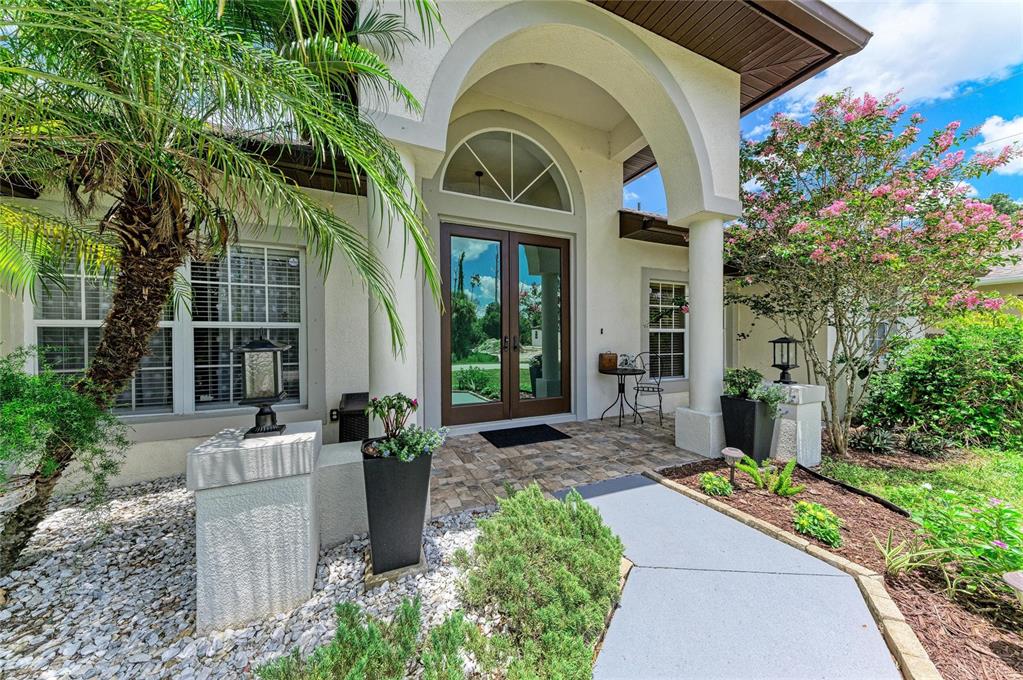 A paved walkway leads to the front entrance of a house with a palm tree — 16352 CHICOPEE AVENUE, PORT CHARLOTTE, FL