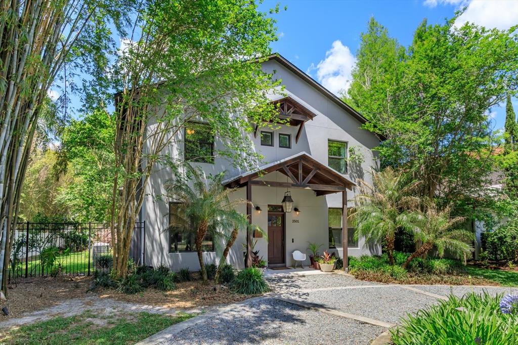 A detached garage with a brown door sits on a gravel driveway with concrete strips — 2501 WINTER PARK ROAD, WINTER PARK, FL