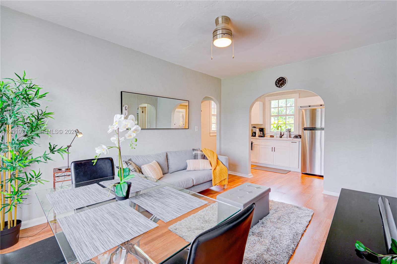 A dining area with a glass table opens into a kitchen through an arched doorway — 227 SW 30th Ave # B, Miami FL 33135, MIAMI, FL