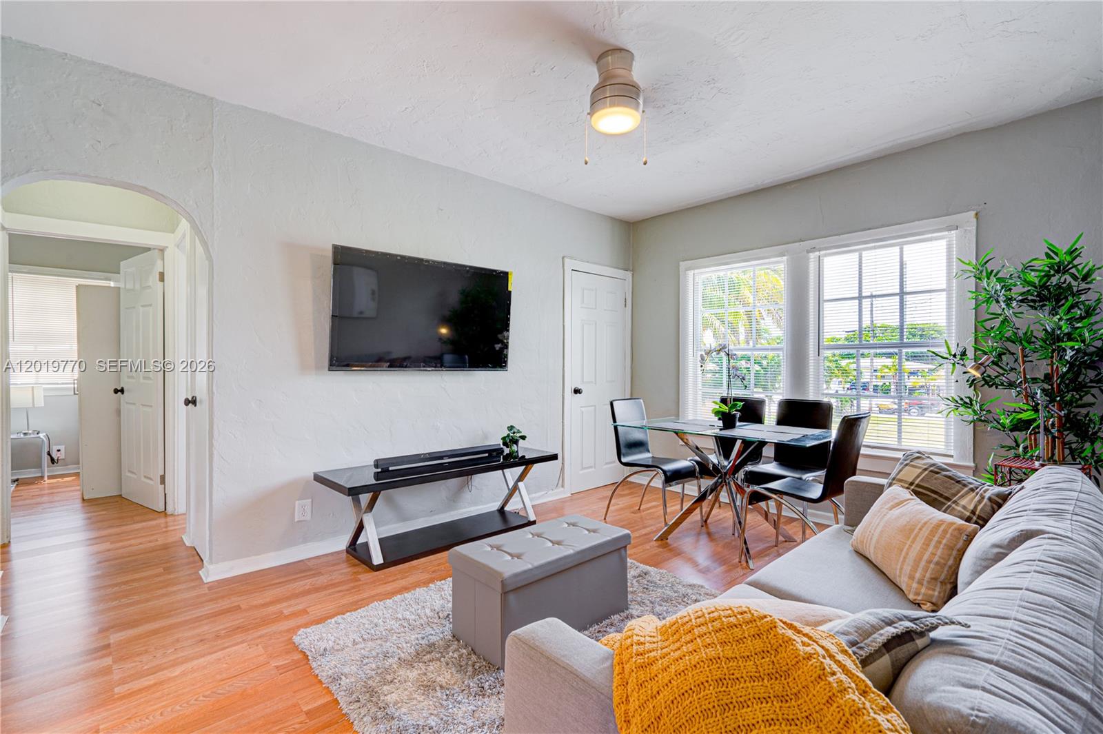 A living room features a wall-mounted television, a dining set, and hardwood flooring — 227 SW 30th Ave # B, Miami FL 33135, MIAMI, FL