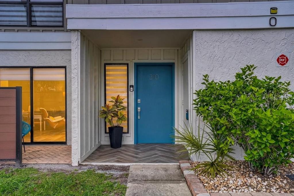 A blue front door with the number 310 is centered under a covered entryway — 4001 BENEVA ROAD UNIT 310, SARASOTA, FL