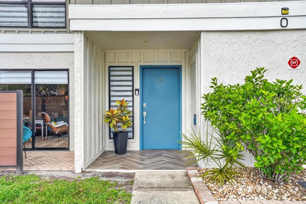 A blue front door with the number 310 is centered under a covered entryway — 4001 BENEVA ROAD UNIT 310, SARASOTA, FL