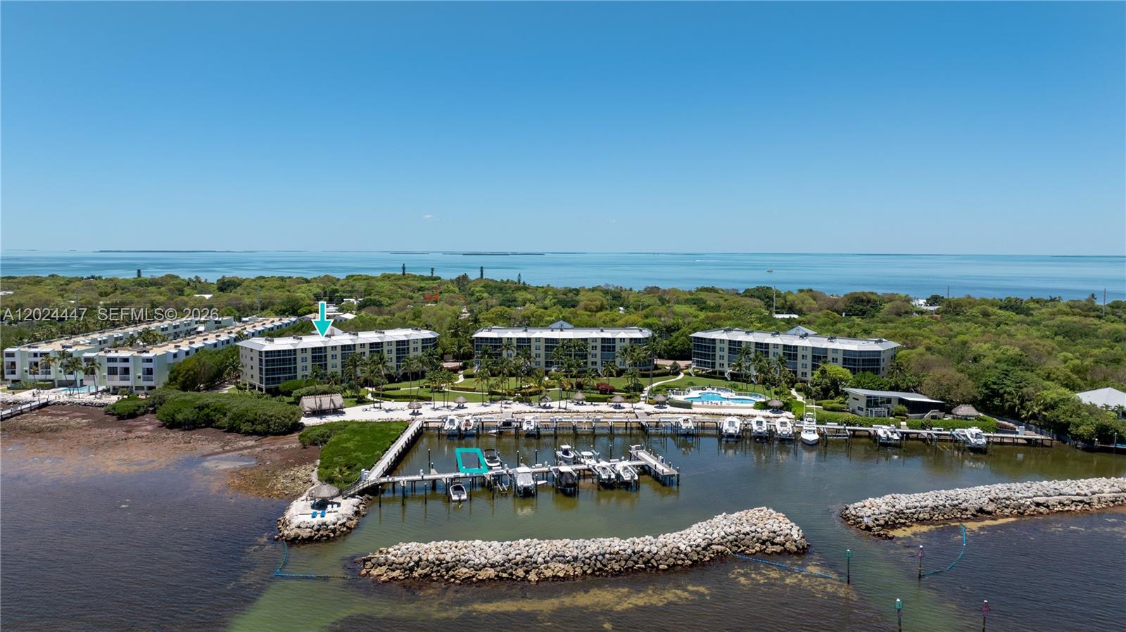 An aerial view shows waterfront apartment buildings with a private marina and swimming pool — 87851 Old Hwy # M42, Islamorada FL 33036, ISLAMORADA, FL
