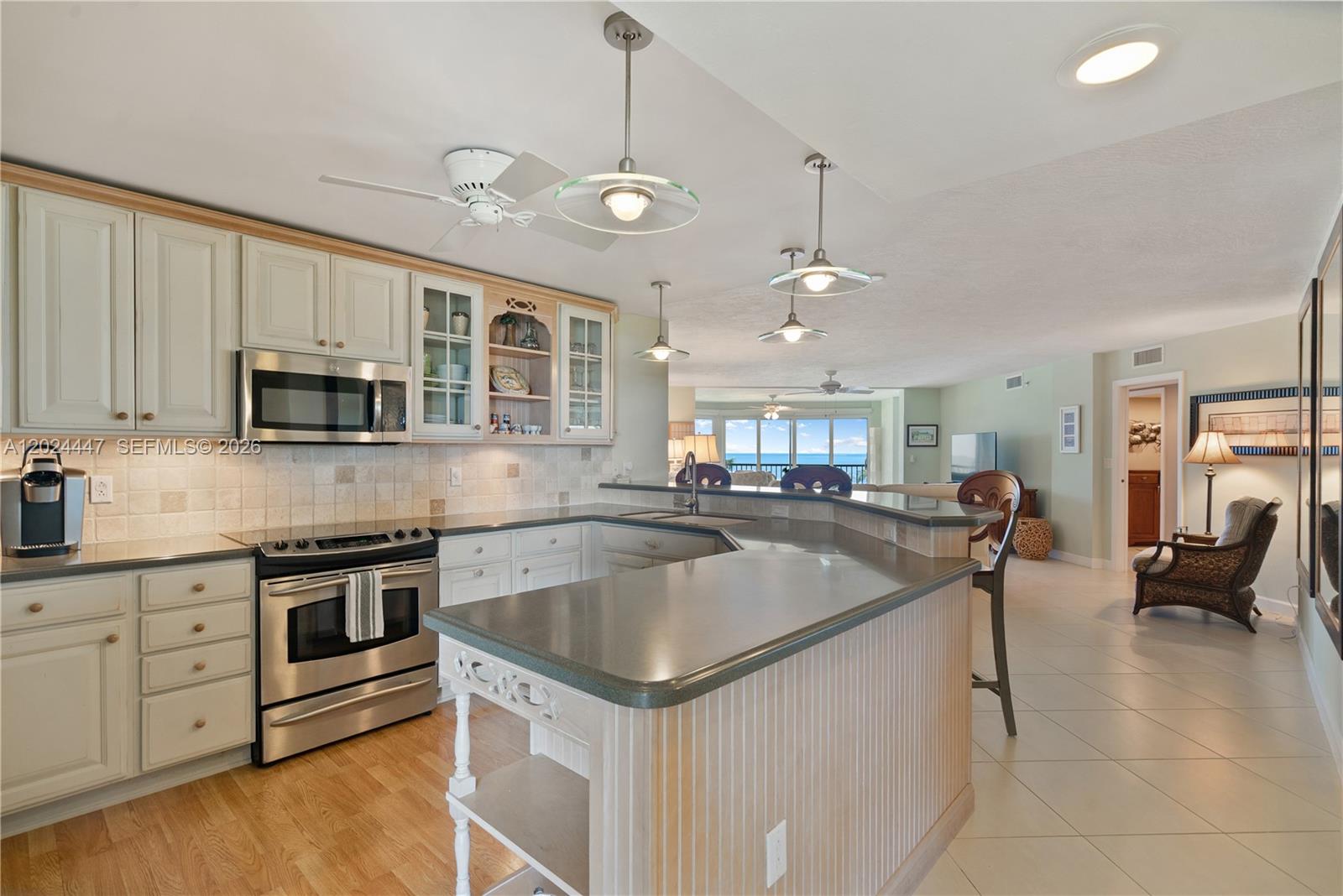 A kitchen with light-colored cabinets, stainless steel appliances, and a peninsula island overlooks the ocean — 87851 Old Hwy # M42, Islamorada FL 33036, ISLAMORADA, FL
