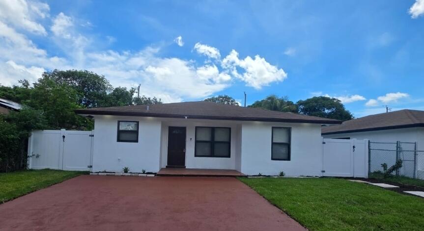 A single-story white house with a brown roof, dark trim, and a red concrete driveway — 320 Sterling Avenue, Delray Beach FL 33444, DELRAY BEACH, FL