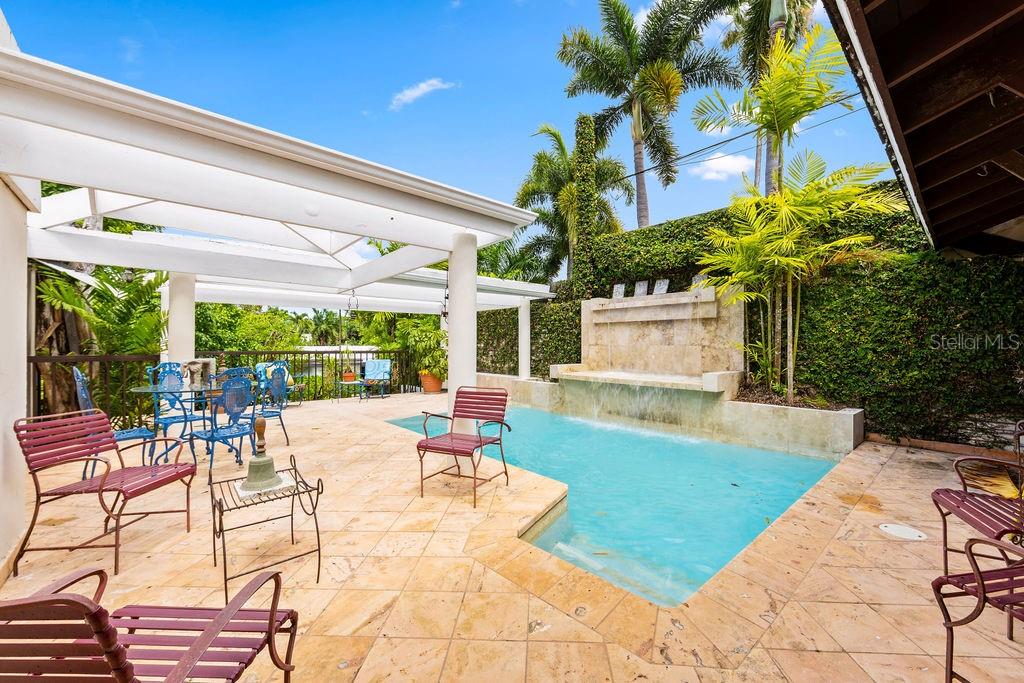 A patio with a swimming pool, a stone water feature, and metal furniture — 1889 ORQUIDEA, SAN JUAN, PR