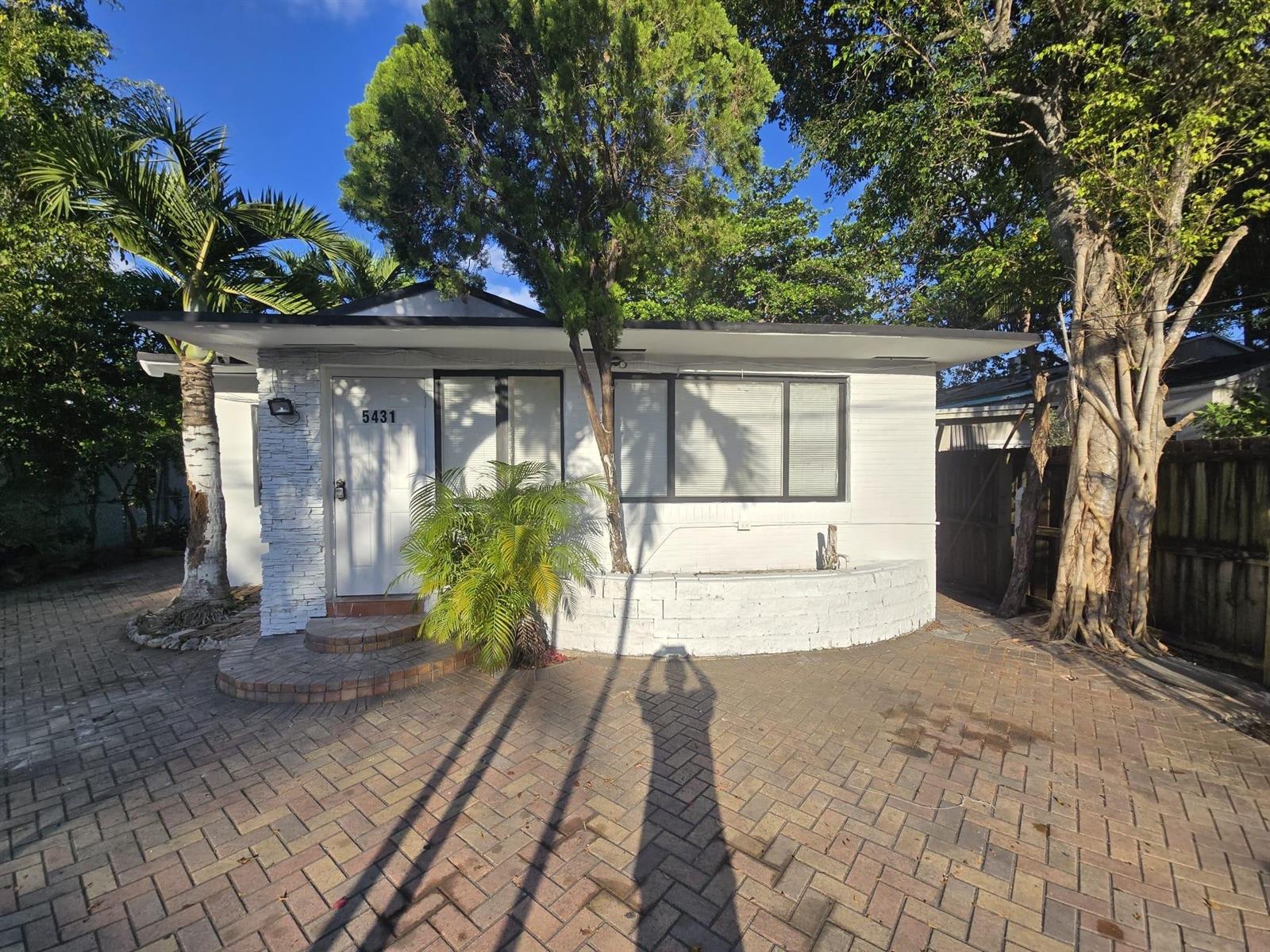 A white single-story house with a brick driveway, palm tree, and stone accents — 5431 NW 30th Avenue, Miami FL 33142, MIAMI, FL