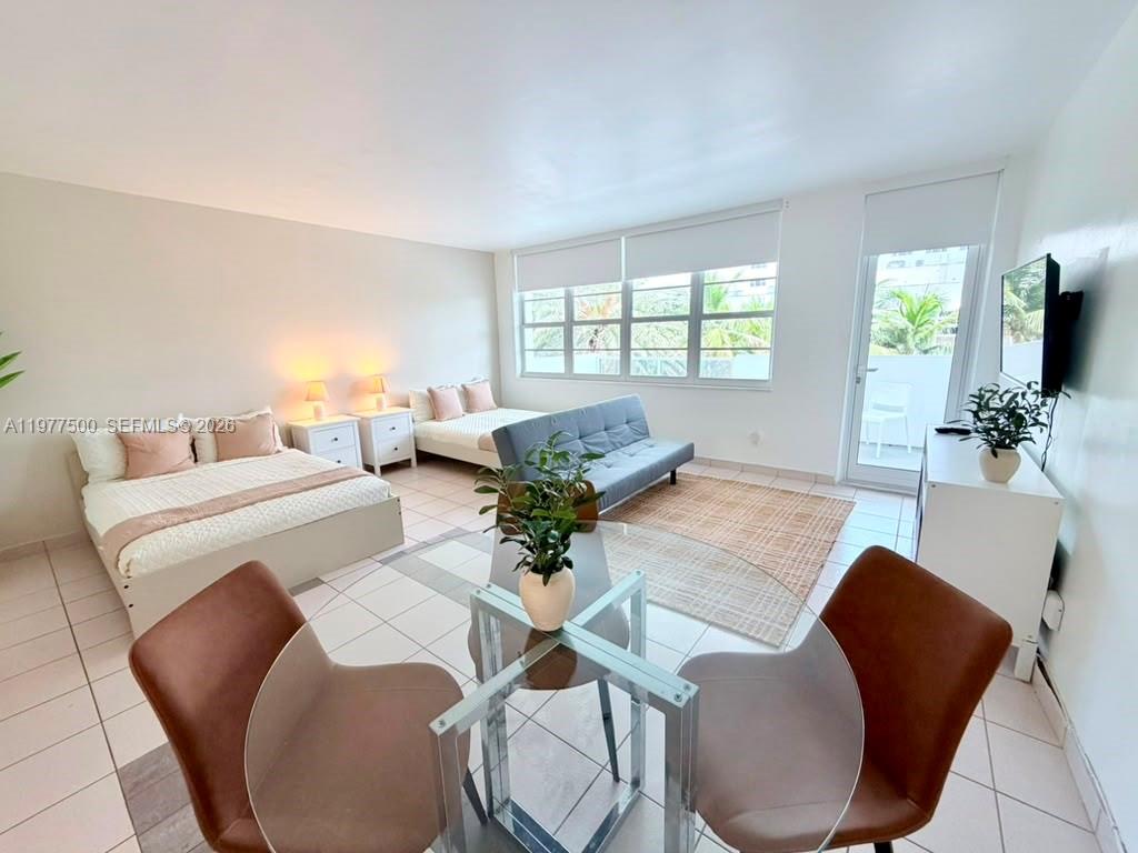 This studio apartment features two beds, a sofa, a dining set, and large windows — 100 Lincoln Rd # 304, Miami Beach FL 33139, MIAMI BEACH, FL