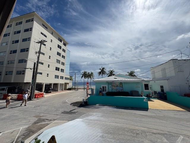 A street view shows a multi-story apartment building, a turquoise house, and palm trees — 308 Monroe Street, Hollywood FL 33019, HOLLYWOOD, FL