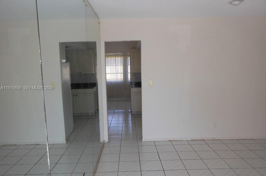 A view through a doorway shows a kitchen with white cabinets and tiled floors — 4955 NW 55th St, Tamarac FL 33319, TAMARAC, FL