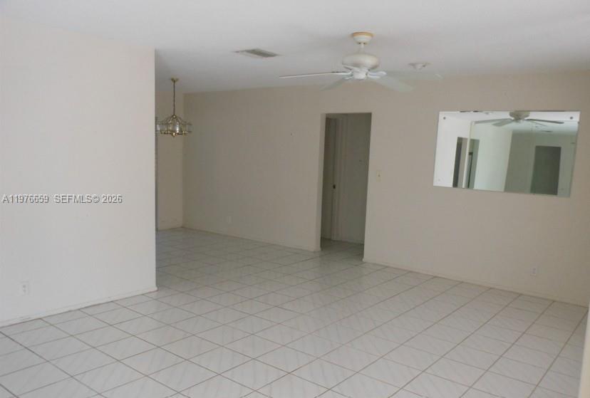 An interior view shows a tiled living area with a ceiling fan and wall mirror — 4955 NW 55th St, Tamarac FL 33319, TAMARAC, FL