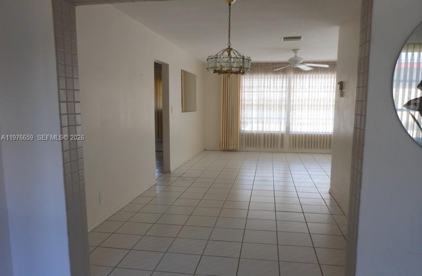 A dining area features white tile flooring, a chandelier, and a ceiling fan — 4955 NW 55th St, Tamarac FL 33319, TAMARAC, FL