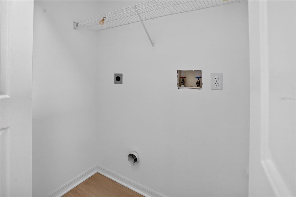 A laundry closet features a wire shelf, water hookups, a dryer vent, and an electrical outlet — 1317 HOMEWAY LANE, DELTONA, FL