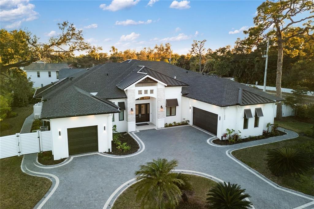 An aerial view of a modern white house with a dark roof and paved driveway — 1800 WEBBER STREET, SARASOTA, FL
